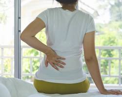 Mulher sente dor nas costas; a lombalgia é uma dor ósteo-muscular-ligamentar (mecânica) nas costas:
envolve, portanto, diversos componentes