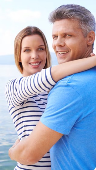 Casal se abraça ao sorrir para foto. A vida é feita de fases e até mesmo uma reversão de vasectomia é possível. Afinal, as decisões que tomamos hoje podem não refletir nossos desejos daqui a alguns anos.
