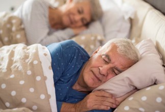 Idosos são vistos dormindo em uma cama. A noctúria, caracterizada pelo ato de acordar à noite para urinar, é uma queixa muito comum entre homens acima dos 40 anos. Além de atrapalhar o descanso, ela pode estar relacionada à saúde da próstata, alterações na bexiga, hábitos diários e até problemas que afetam a qualidade do sono.